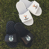 iSlide Hardwood Classics '68 Mantra Milwaukee Bucks Sandals In Black - Lifestyle Shot Of Sandals On Ground