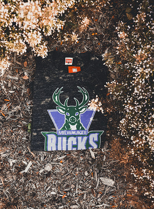 Homage HWC '93 Charcoal Milwaukee Bucks Long Sleeve T-Shirt In Grey - Front View Lifestyle Photo Folded On Ground